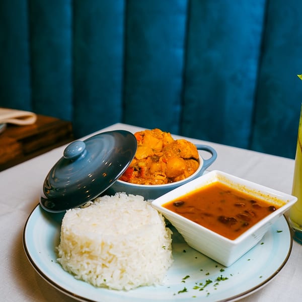 A plate of white rice, a bowl of red bean stew, and a pot of chicken curry.